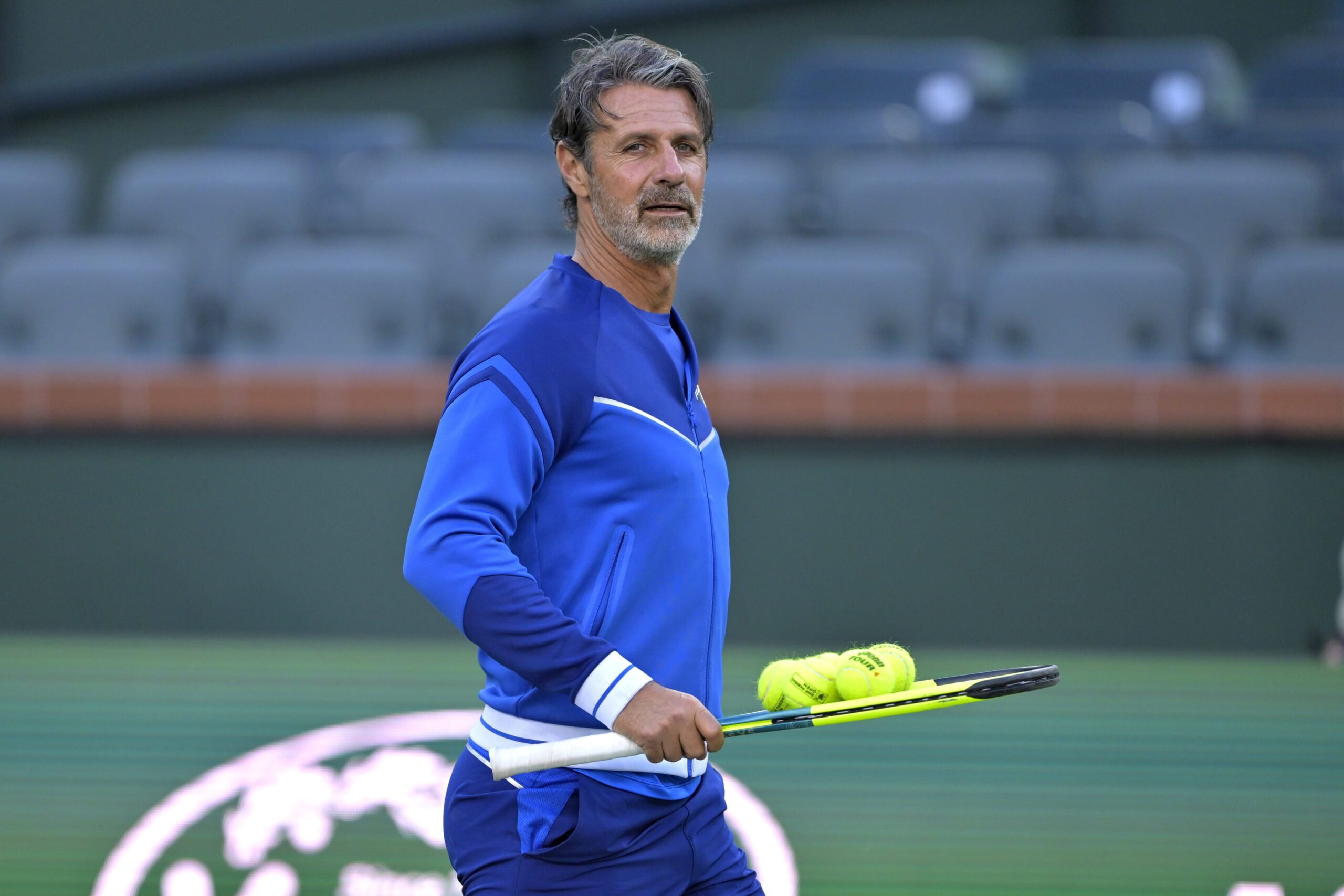 Patrick Mouratoglou, coach of Naomi Osaka, picks up some practice balls during the first day of the BNP Paribas open at the Indian Well Tennis Garden